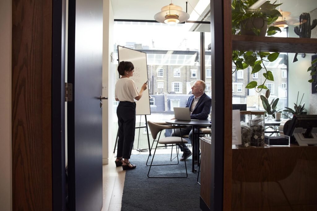 pexels-photo-2977547-2977547 Colleagues engage in a strategic business meeting in a contemporary London office with city views.